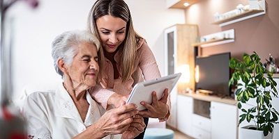 A woman looking at tablet with her elderly mom