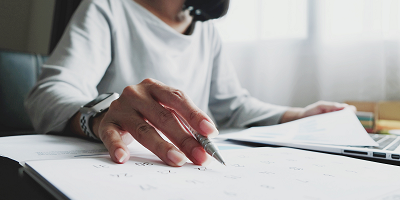 Woman holding a pen and checking a date on a calendar