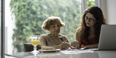 Granddaughter helping grandmother with laptop