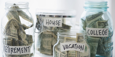 Four jars of money labeled retirement, house, vacation and college. 