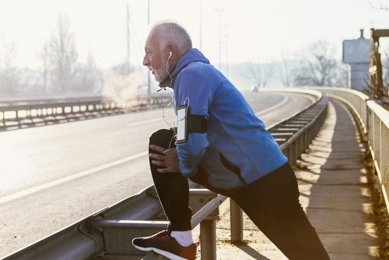 Older man stretching in preparation for a run.