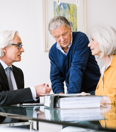 Financial advisor sitting with his mature clients as they plan for retirement. 