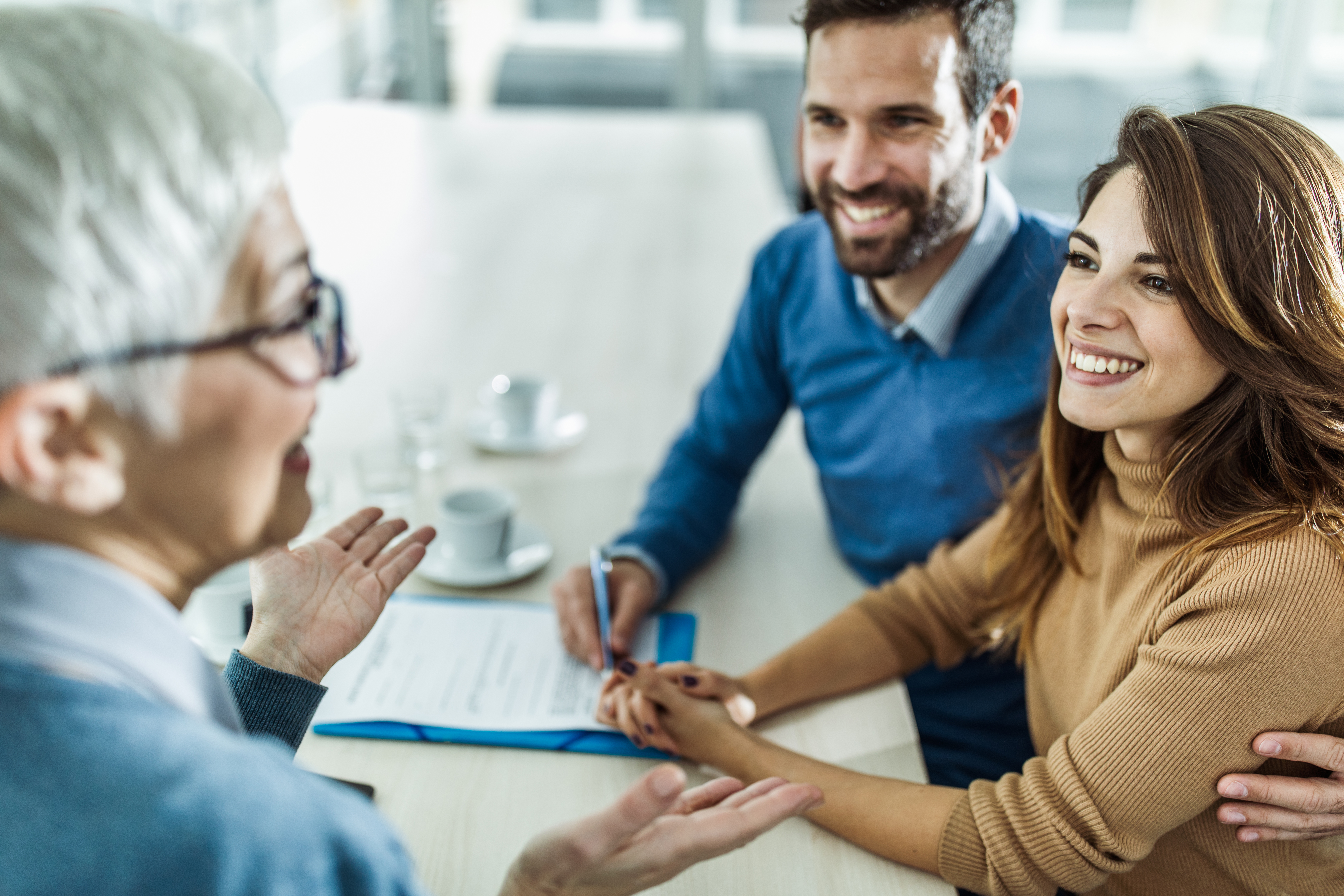 Financial advisor working with a young couple to create a life insurance policy that fits their needs.