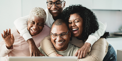 Smiling parents and adult children using a laptop for a video call