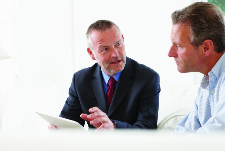 Financial advisor discusses life insurance medical exam process with client.