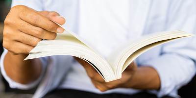 Male hands holding an open book