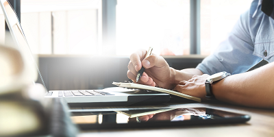 Man writing in notebook at desk