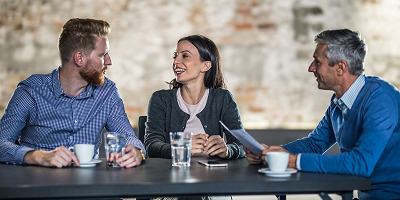 A young, millennial couple sitting at a bar with their financial professional.