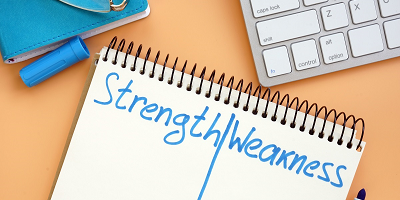 A notepad reading strengths and weaknesses. 