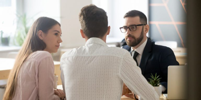 Young couple sits down with their financial advisor to discuss bull and bear markets. 