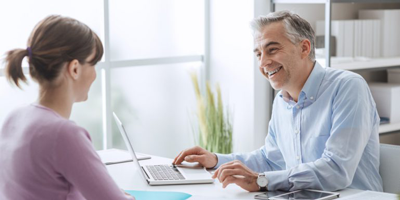 Male financial representative smiling while speaking with his female client. 