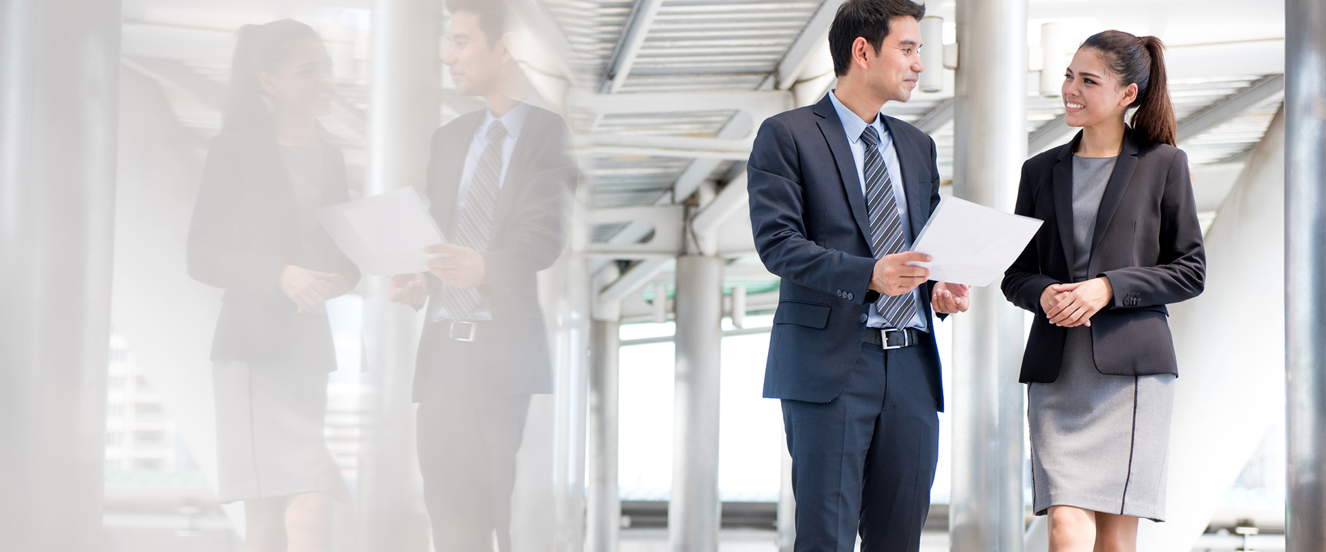 Young man and woman discussing business while walking through an office building